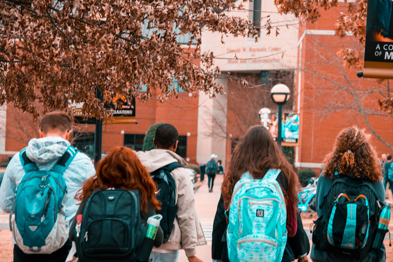 A group of diverse students walking together along a sidewalk, engaged in conversation and enjoying their time outdoors.