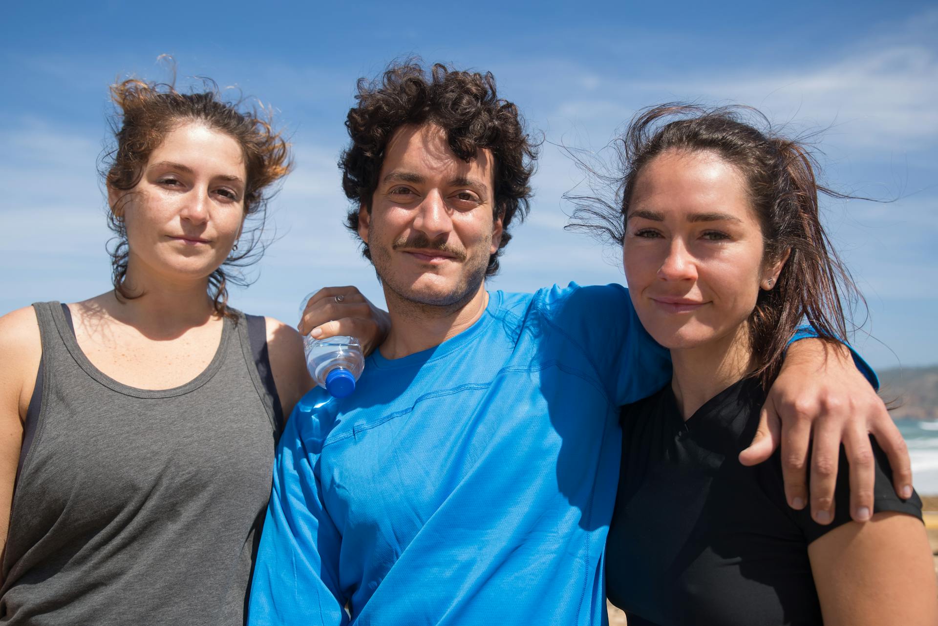 Man in Blue Long Sleeve Shirt Standing Beside Two Women